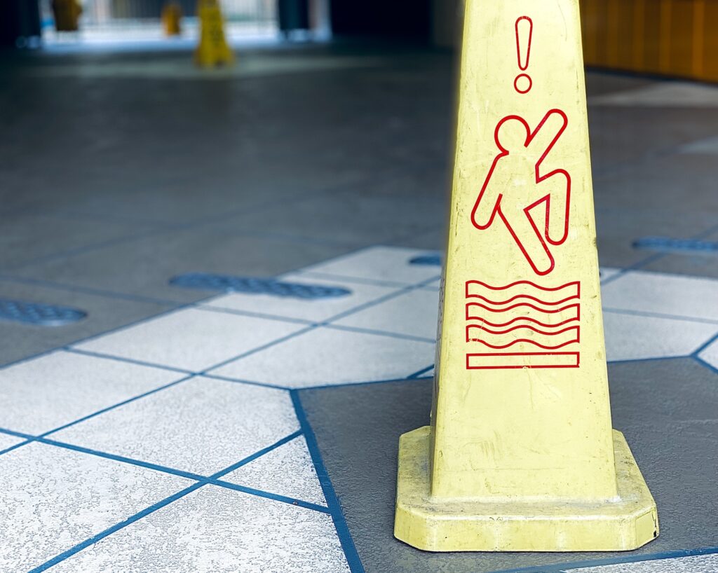 Warning sign cone that there is danger of slipping on a wet slippery floor. White space for text